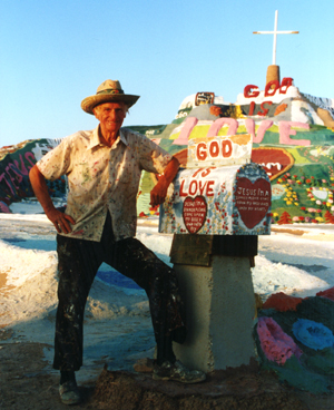 Leonard Knight next to his Salvation Mountain.