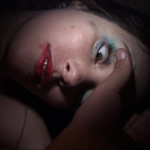 A passed out girl has her eyelid opened