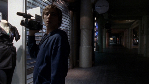 Teenage boy with a video camera films at the mall