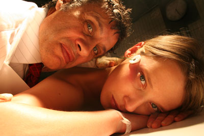 Crazed doctor and female victim stare into the camera