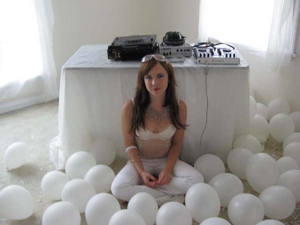 Actress Christine Robertson sits in a pile of white balloons