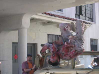 Zombie flies over the windshield of a Humvee