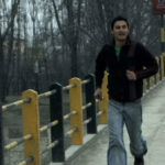 Kashmir man runs across a bridge