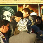 Iraqi citizens walk in an open Iraq market in Kadhimiya