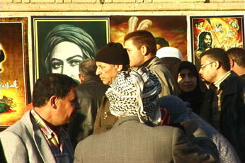 Iraqi citizens walk in an open Iraq market in Kadhimiya