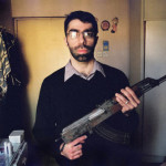 Filmmaker Usama Alshaibi poses while holding a rifle in Baghdad