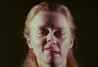 Film still from Hollis Frampton's film Zorns Lemma featuring a woman with a split face