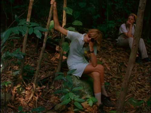 Pretty girl in blue dress sitting in the jungle