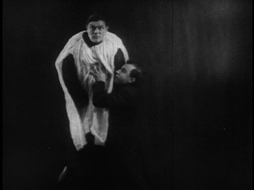 A priest pushes a man hanging from a rope