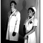 The Doctor and Nurse Jennifer (Bret Logan, Kristina Powis) study their patient