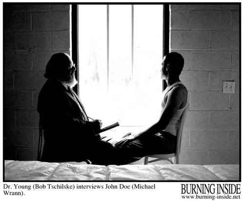 A bearded man and a young man sit in front of a hospital window