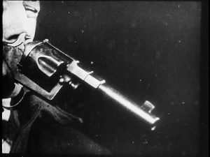 Close-up of a man pointing a gun
