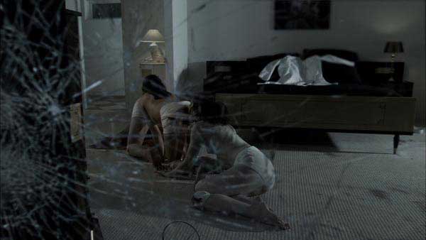Three people sewn together crawl along the floor