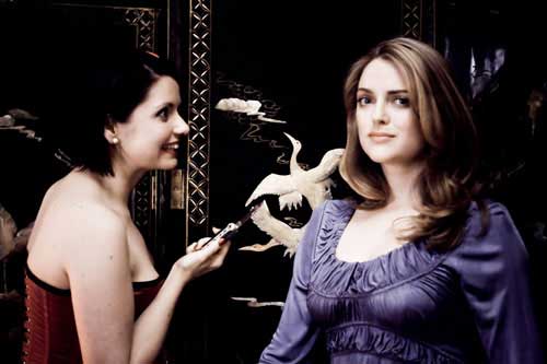 Woman in lingerie points knife at pretty woman