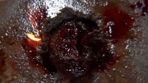 A bloody face burns on the ground