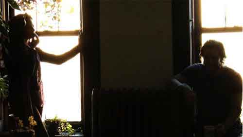 Woman and man are in silhouette in front of windows