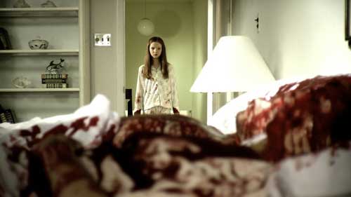 Young girl in pajamas looks over her mother's bloody corpse