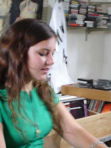 Teenage girl in green t-shirt in music store