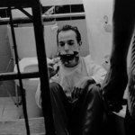 Man missing his lower jaw sits on a bathroom floor