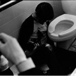 Cinematographer sits on the floor of a bathroom