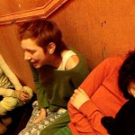 Three woman sit in a stairwell