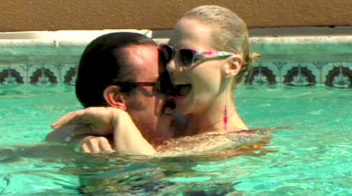 Man cuddles a woman in a swimming pool