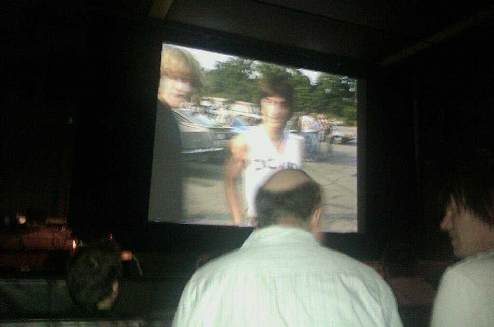 The back of filmmaker Jeff Krulik's head while his film plays on-screen
