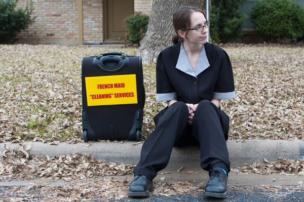Cleaning woman sitting on the curb
