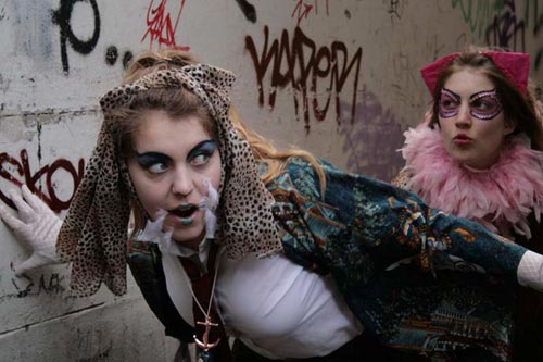 Two teenage girls run around wearing outlandish costumes