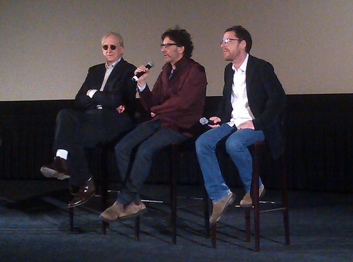 T-Bone Burnett, Joel Coen and Ethan Coen sit in directors chairs
