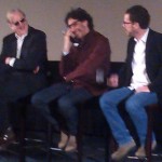T-Bone Burnett, Joel Coen and Ethan Coen sitting on stage laughing