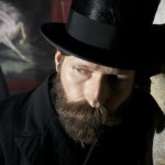 Crispin Glover with a thick beard and stovepipe hat