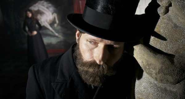 Crispin Glover with a thick beard and stovepipe hat