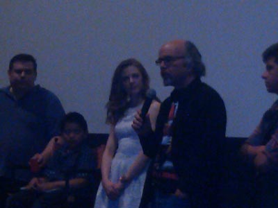 Clint Howard address the audience after a movie screening while Ashley Bell looks on