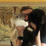 Filmmaker Ben Popp holds his two cats, one white and one black, up to his face