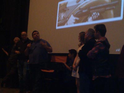 Christopher Folino looks at his film's credits rolling onscreen while talking to the audience