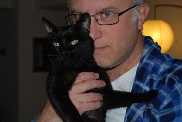 Filmmaker Jeff Krulik holds his black cat Iggy up to his face