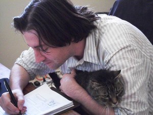 Filmmaker Waylon Bacon draws storyboards for his next film while his cat Lou Rawls keeps him company