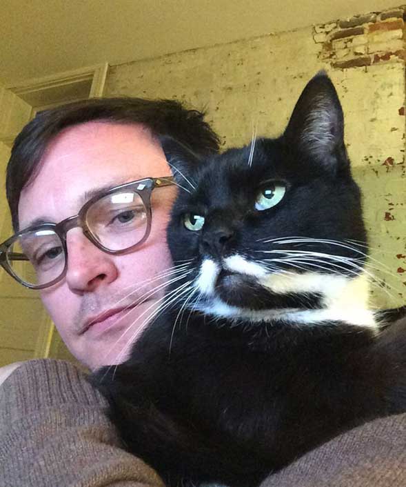 Brian L. Frye holds his black and white and moustached cat named T.J. Hooper