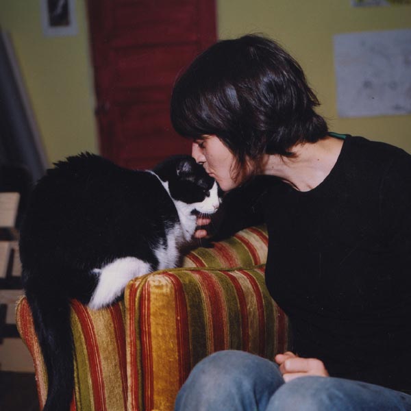 Animator Jo Dery gives her black and white cat Panda a kiss on the head.