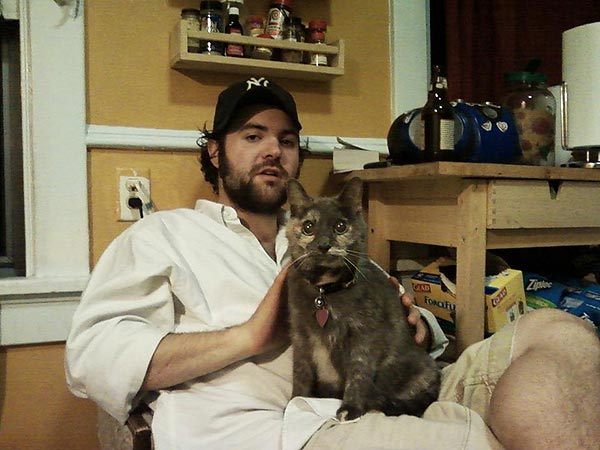 Filmmaker Josh Weissbach sits with his deaf and blind cat, Giblet, on this lap.