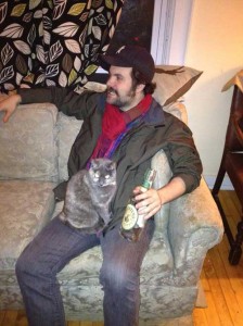 Filmmaker Josh Weissbach relaxes with a bottle of alcohol and his deaf and blind cat, Giblet.