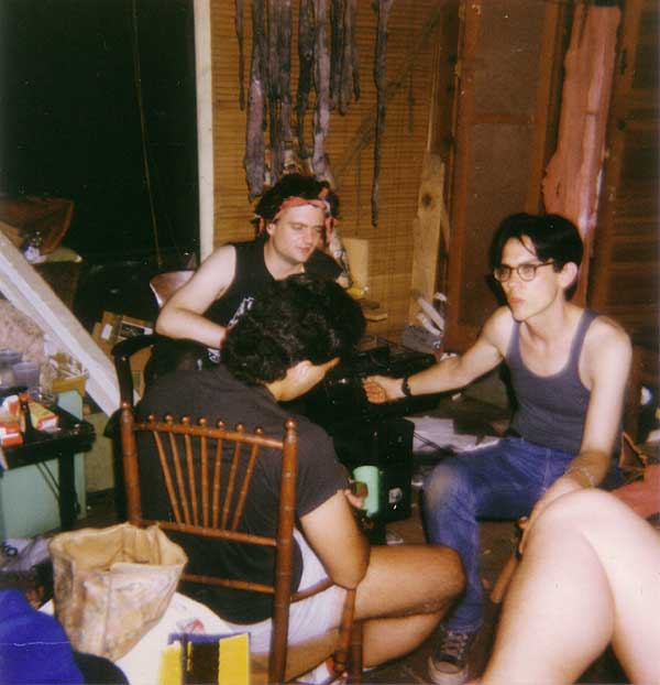 Bunch of guys sitting around on a messy, crowded film set interior