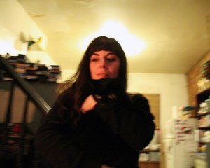 A slightly out of focus photo of Christine Lucy Latimer hugging her black cat Mingus