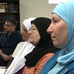 Usama Alshaibi sits in a row with Arab women wearing their hijab