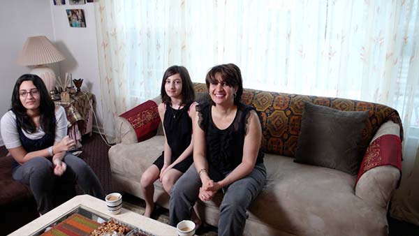 Three women of the Jassar family sit in the family room of their Chicago apartment