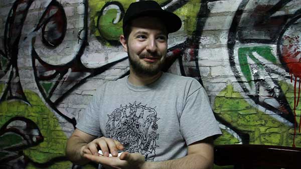 Musician Marwan Kamel sits in front of a graffiti covered wall