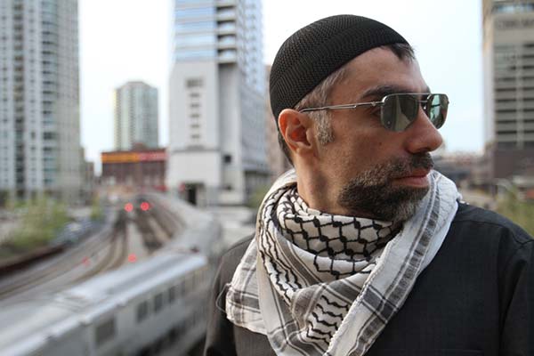 Usama Alshaibi stands on a Chicago street