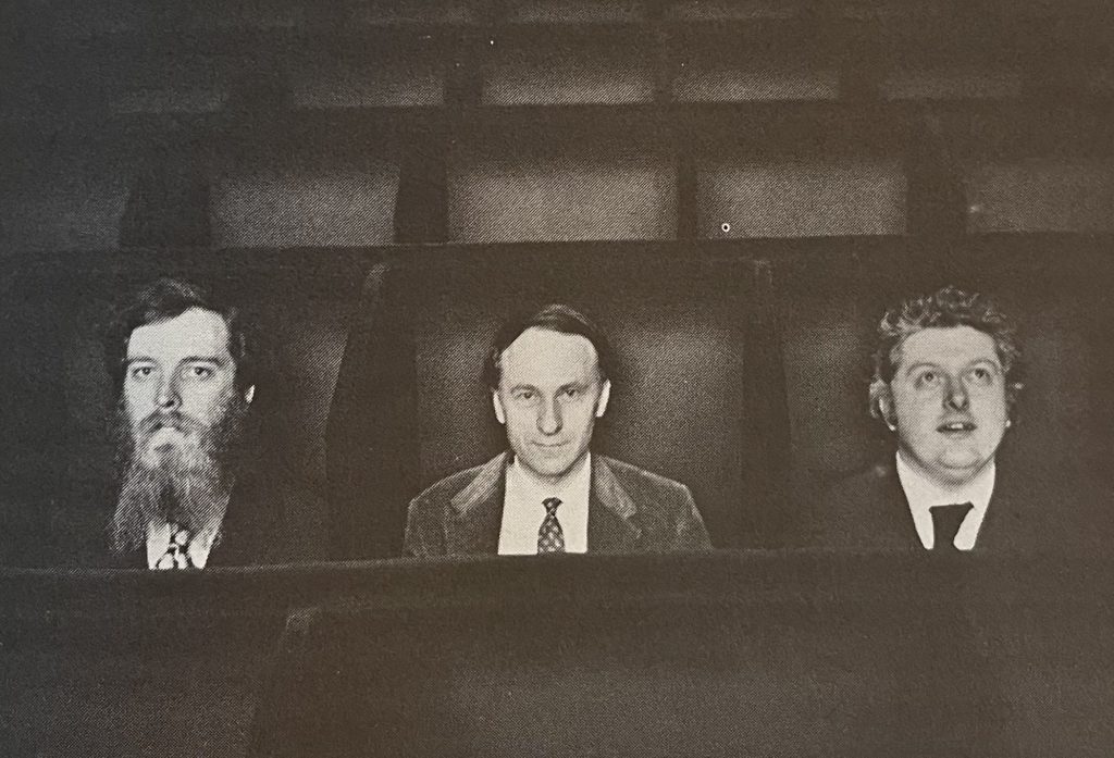 Jonas Mekas sits in the Invisible Cinema between P. Adams Sitney and Peter Kubelka