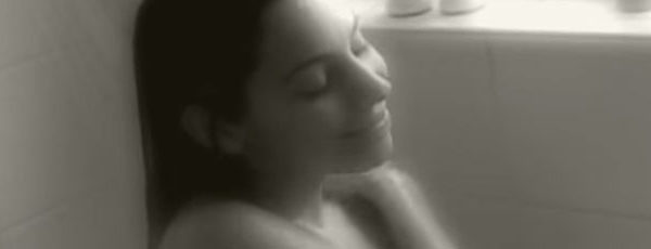 Film still of a woman sitting in the shower